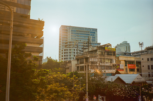 Bangkok cityscape  in warm rays of sunset. Shot on camera film with vintage effect