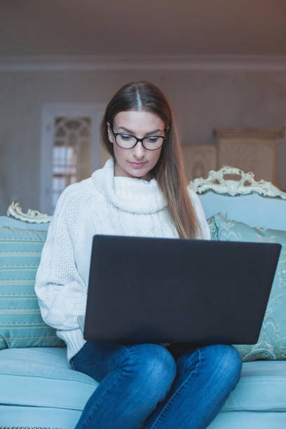 istock Pretty serious woman working using laptop at home 1780368546