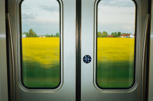 Scenic view of yellow  rapeseed field through the window of regional train  in Europe