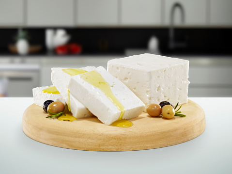 Cheese plate full of fresh Feta cheese on a kitchen island inside of a domestic kitchen