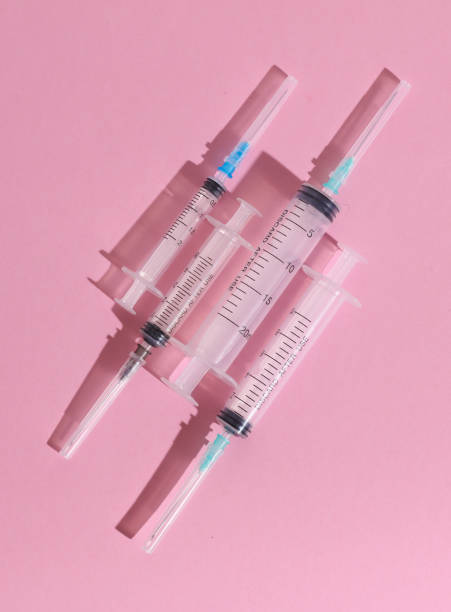 istock Different medical syringes on pink background with shadow. Minimalism medical layout 1780377762