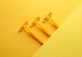 Three yellow razors on yellow background