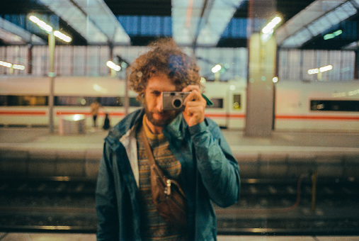 Selfie of man in the mirror on train platform during his travels