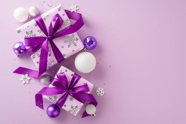 istock Express your joy through this present-themed image. A top view of elegant lilac gift boxes, celebratory baubles, sparkling sequins, snowflakes set against purple backdrop for your text or advert 1780388857