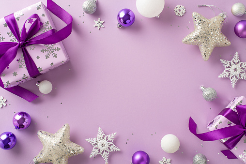 Offer your warm wishes with this beautiful gift image. Top view of exquisite gift boxes, celebratory baubles, sparkling stars, sequins, snowflakes against lilac backdrop, providing space for your ad