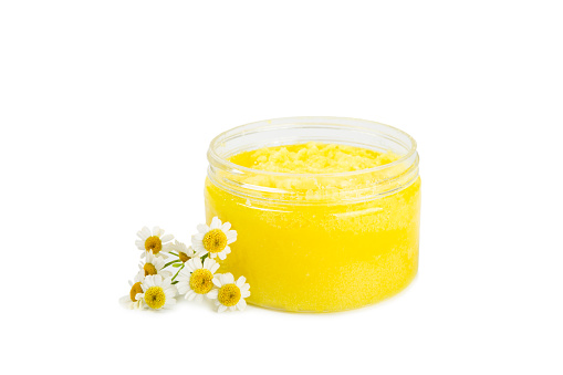 Chamomile body scrub with herbal chamomile extract isolated on white background. Skin softening scrub. Body care cosmetics, natural organic product, herbal medicine. Beauty concept.