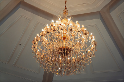 Luxury interior chandelier has light candles and dark background