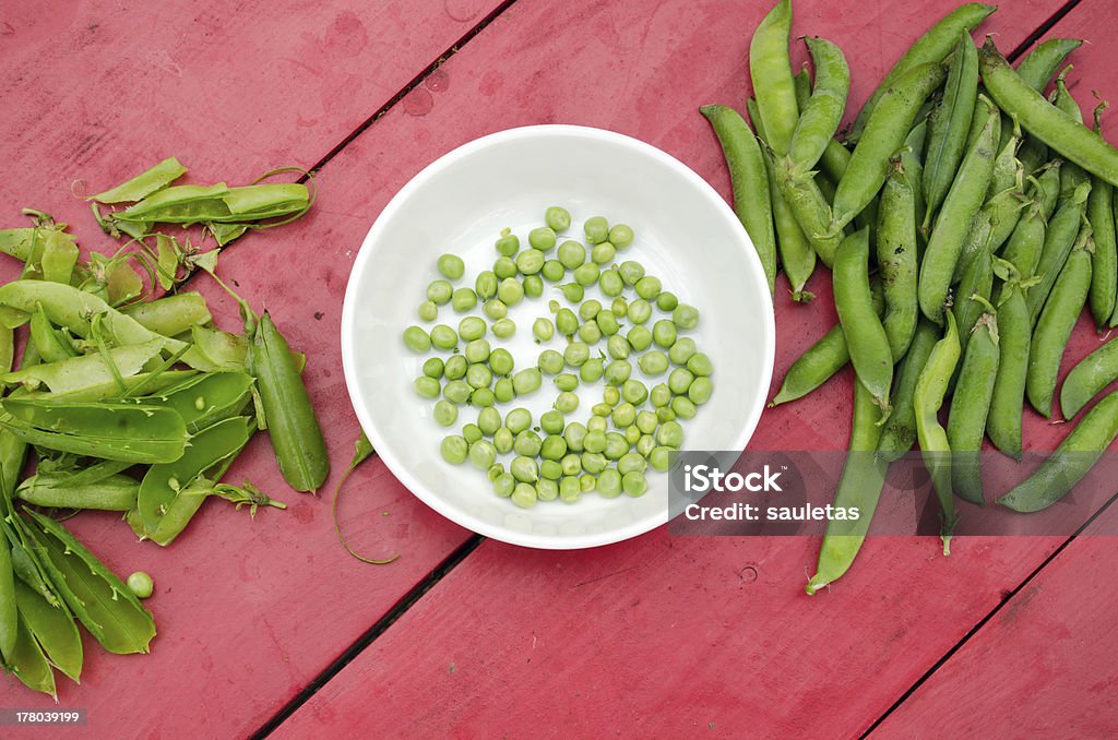 peas shell husk white plate dish red table green peas husked shelled in white plate dish on red wooden table. Activity Stock Photo