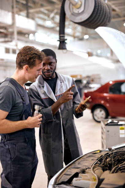 istock team of two men mechanic inspection checking bug in engine from smartphone. 1780413260