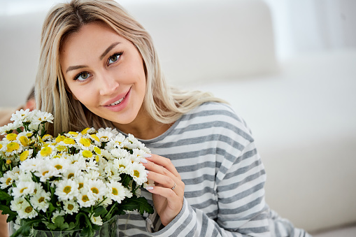 Close-up of a gorgeous girl holding yellow flowers
