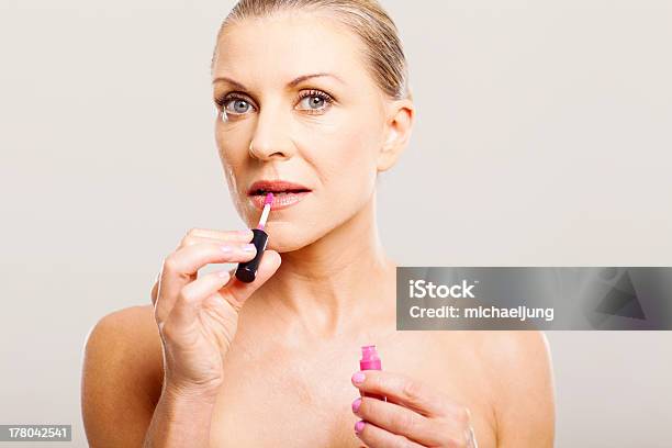 Older Woman Putting Lip Gloss Stock Photo - Download Image Now - 50-59 Years, 60-69 Years, Adult
