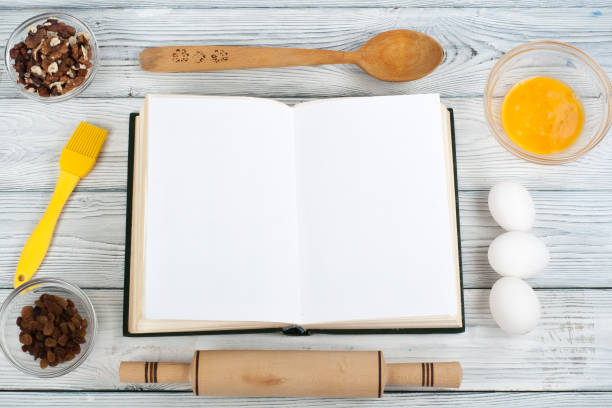 istock Recipe cook blank book on wooden background, spoon, rolling pin, checkered tablecloth. Top view 1780426149