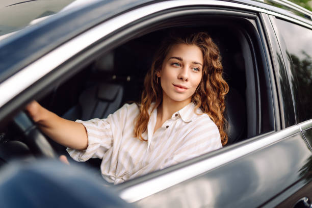 istock Smiling woman driving her car. 1780432042