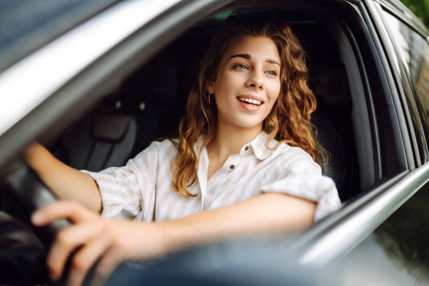 istock Smiling woman driving her car. 1780432047