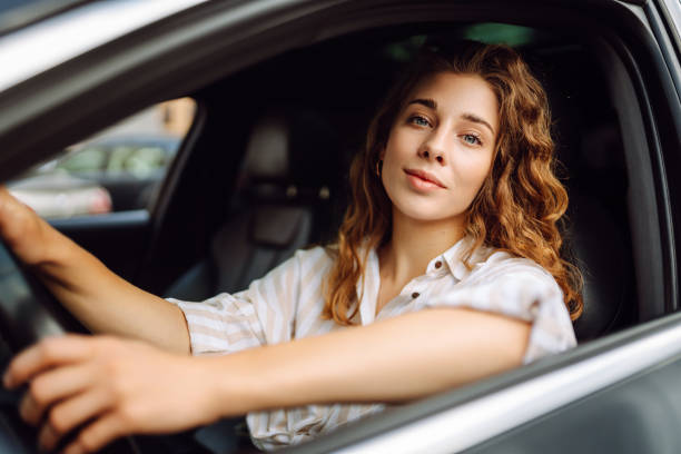 istock Smiling woman driving her car. 1780432573