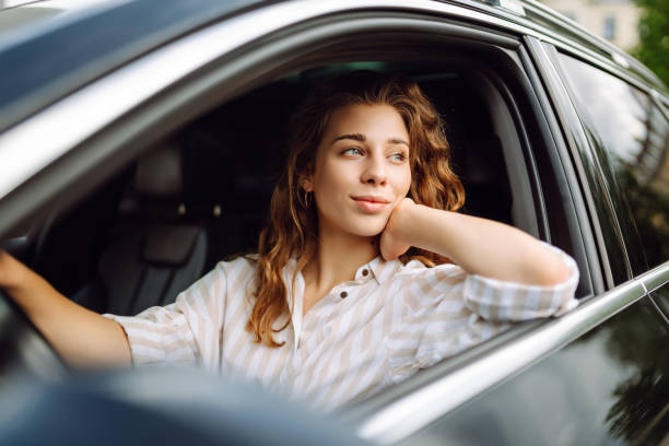 istock Smiling woman driving her car. 1780432599