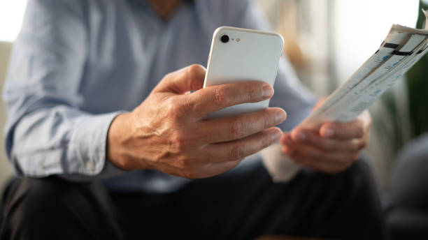 istock Close-up senior man pays bills using smartphone at home 1780435769