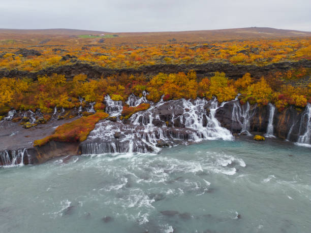 Aerial top view of Hraunfossar waterfall in autumn fall season in Iceland. Famous nature landscape background Aerial top view of Hraunfossar waterfall in autumn fall season in Iceland. Famous nature landscape background hraunfossar stock pictures, royalty-free photos & images