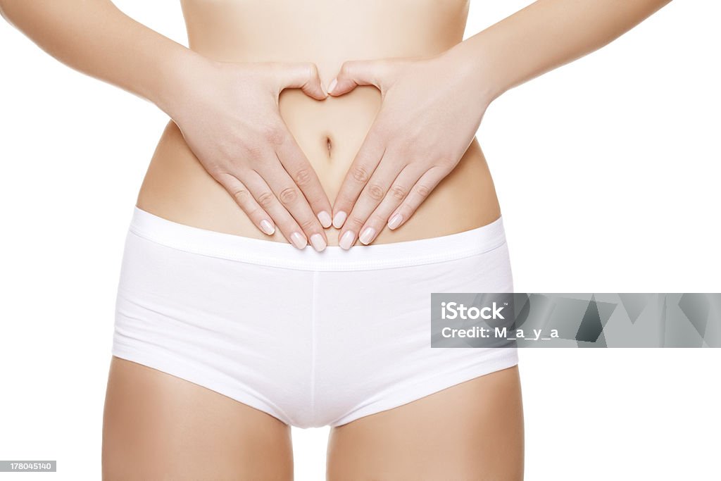 Perfect female body. Shaping hart with hands on stomach. Adult Stock Photo