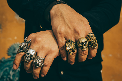 Young man wears rough and masculine rings of different figures such as animals and skulls.