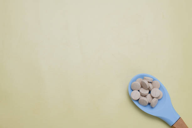 istock Vitamins in a blue spoon onyellow background. 1780461515
