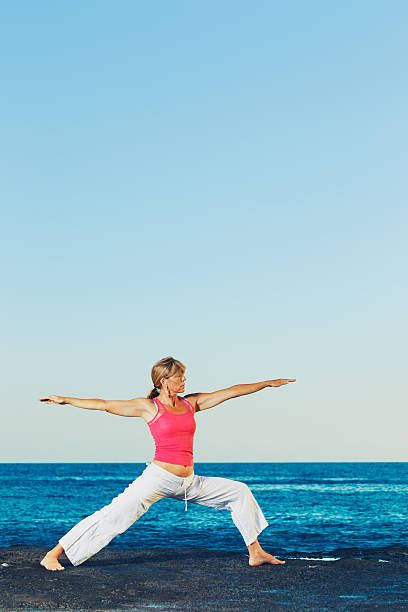istock Woman Practicing Yoga by the Ocean 178046364
