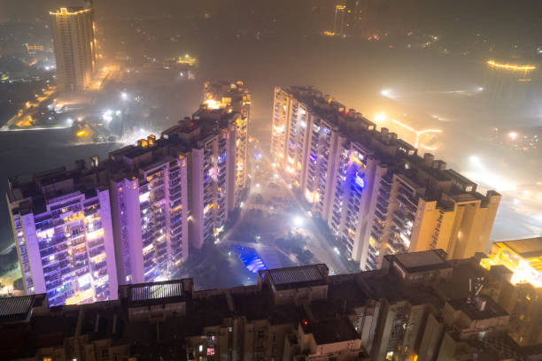 aerial drone shot skyscraper buildings in gurgaon delhi in dense fog smog pollution showing the lavish lifestyle and bad conditions of the city stock photo