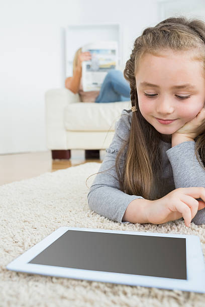 istock Girl using tablet with her mother reading the newspaper 178046851