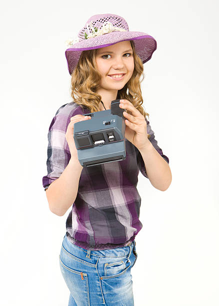 Smiling teenage girl holding a polaroid camera stock photo
