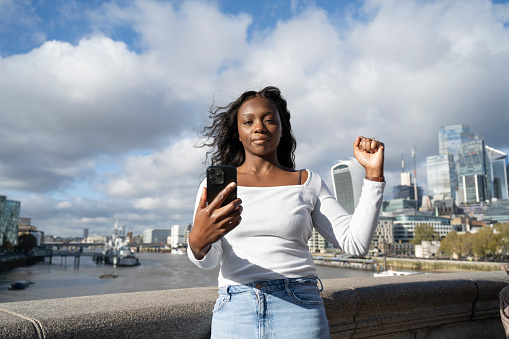 Successful mid adult professional woman with raised fist in London