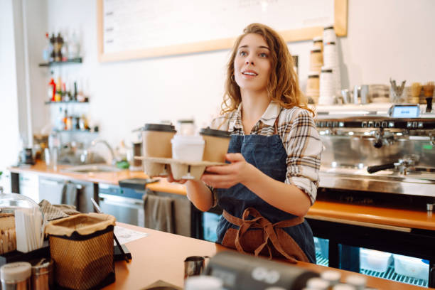 istock Female barista holding disposable takeaway cups. 1780471922