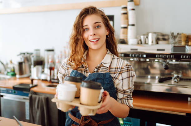 istock Female barista holding disposable takeaway cups. 1780471938