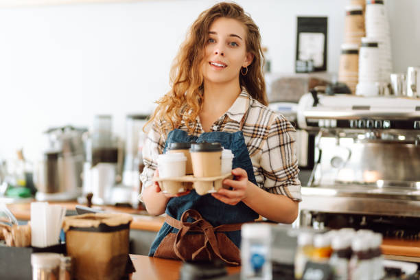istock Female barista holding disposable takeaway cups. 1780471939