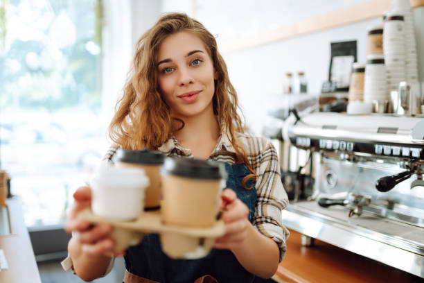 istock Female barista holding disposable takeaway cups. 1780471940