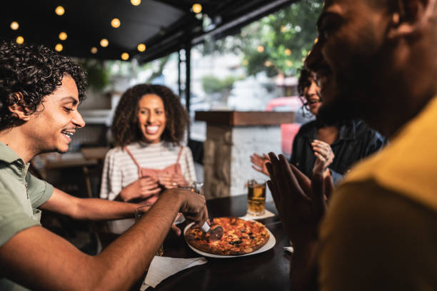 istock Friends cutting a pizza at restaurant 1780477739