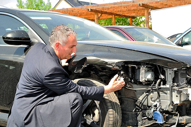 istock A man looking closely at a wrecked car 178048126
