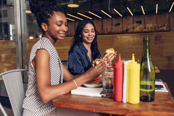 istock Two businesswomen eating hamburger at lunch break 1780491594
