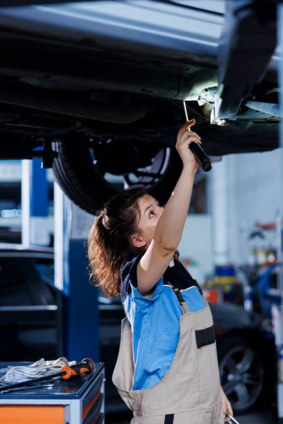 istock Mechanic checks engine on suspended car 1780491597