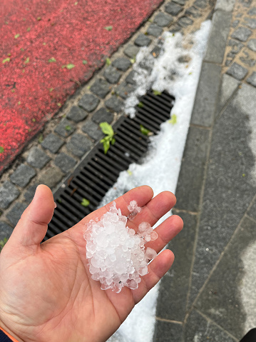 Large hail in human hands on the green grass background. High quality photo