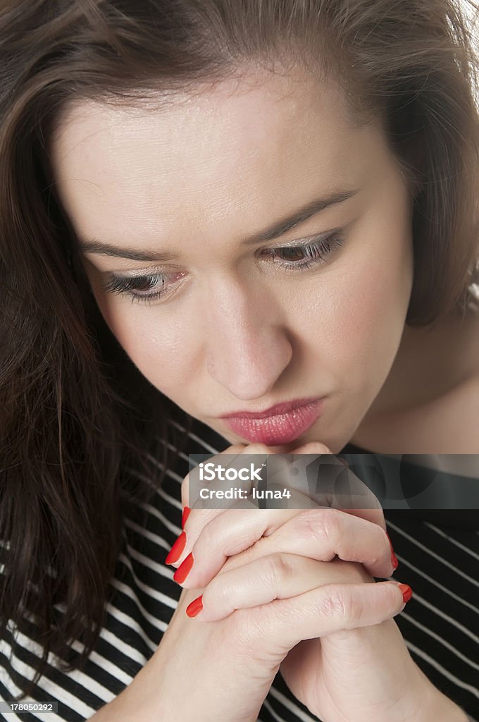 Young Woman Praying brunette young woman having her hands folded in prayer Adolescence Stock Photo