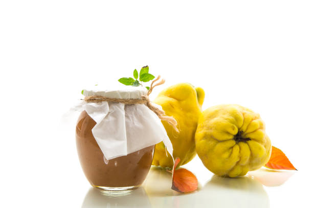 istock Ripe quince fruit with jam in a glass jar isolated on a white background. 1780509451