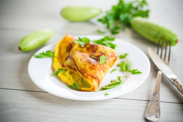 Fried omelet with zucchini, on a wooden table. stock photo