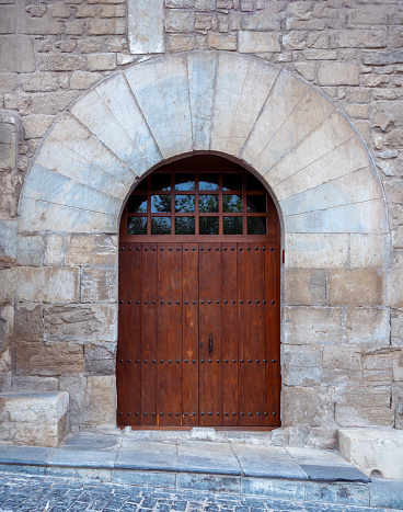 Wooden door on old stone wall