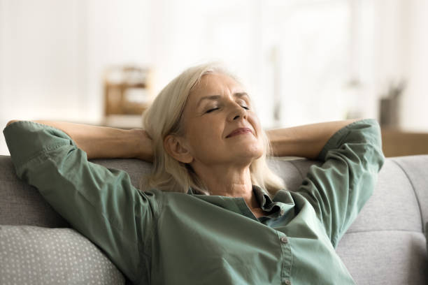 istock Positive tranquil elderly woman relaxing on couch with closed eyes 1780510383