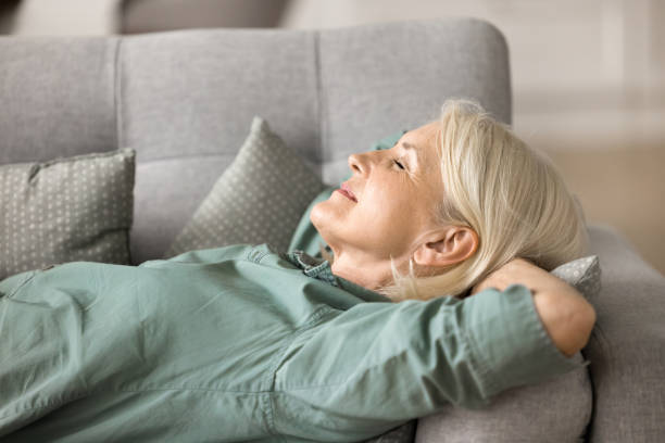 istock Peaceful happy elderly woman resting on soft comfortable sofa 1780510942