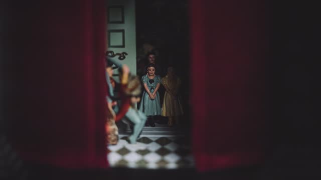 A Group Family of Small Glass Porcelain Doll Figures figurines Inside a Dark Moody Hand Painted Antique Vintage Red Curtain House In Shadow Miniature
