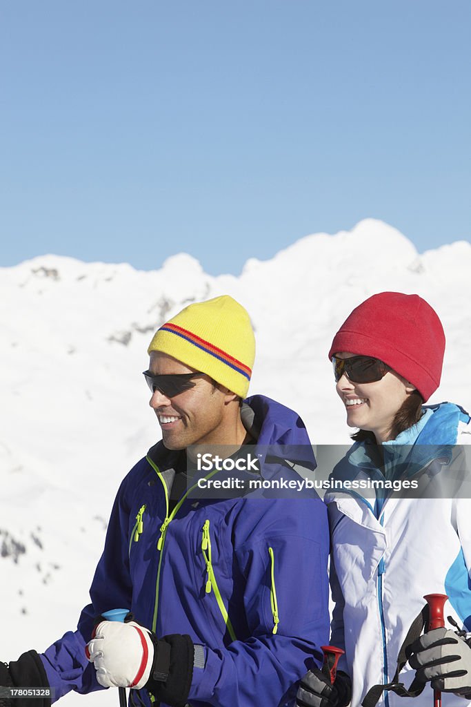 Couple Having Fun On Ski Holiday In Mountains Couple Having Fun On Ski Holiday In Mountains Looking Away From Camera Smiling 40-49 Years Stock Photo