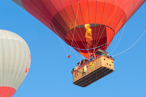A Hot Air Ballon floats effortlessly in an azure sky above a wide open vista of California real estate. Temecula, CA.