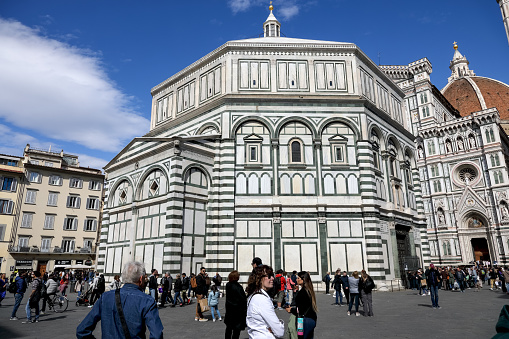 Florence, Italy - April 14, 2023: Battistero di San Giovanni, Florence's baptistery and a fragment of the Duomo, Florence's cathedral. It is one of the most visited places in the city by tourists.