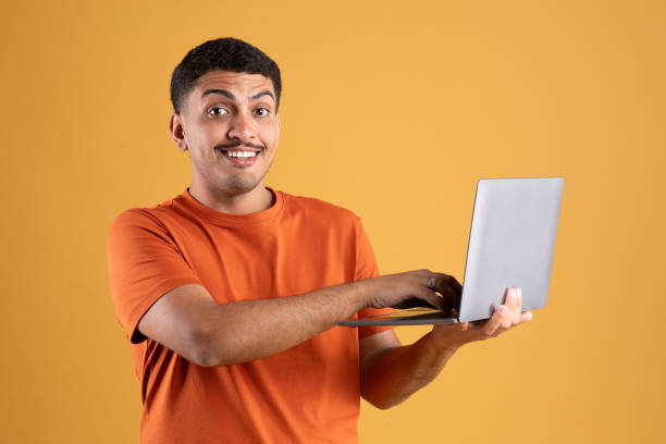 istock Online work. Excited brazilian man freelancer using laptop, working remotely with computer, reading great news and offer 1780537174